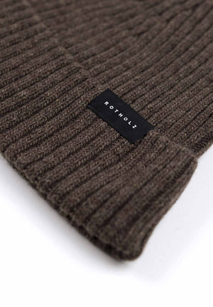 Close up of the brim of a ribbed beanie in brown.