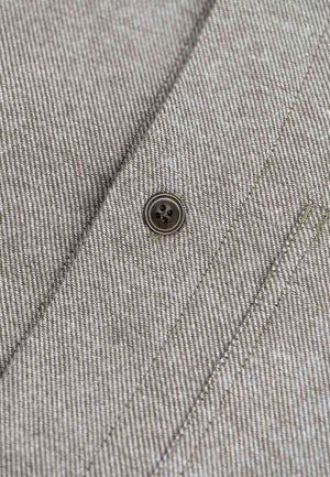 Close up of the button closure of a flannell shirt in brown melange.