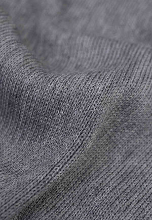 Close up of the knitted fabric of a merino wool scarf in grey.