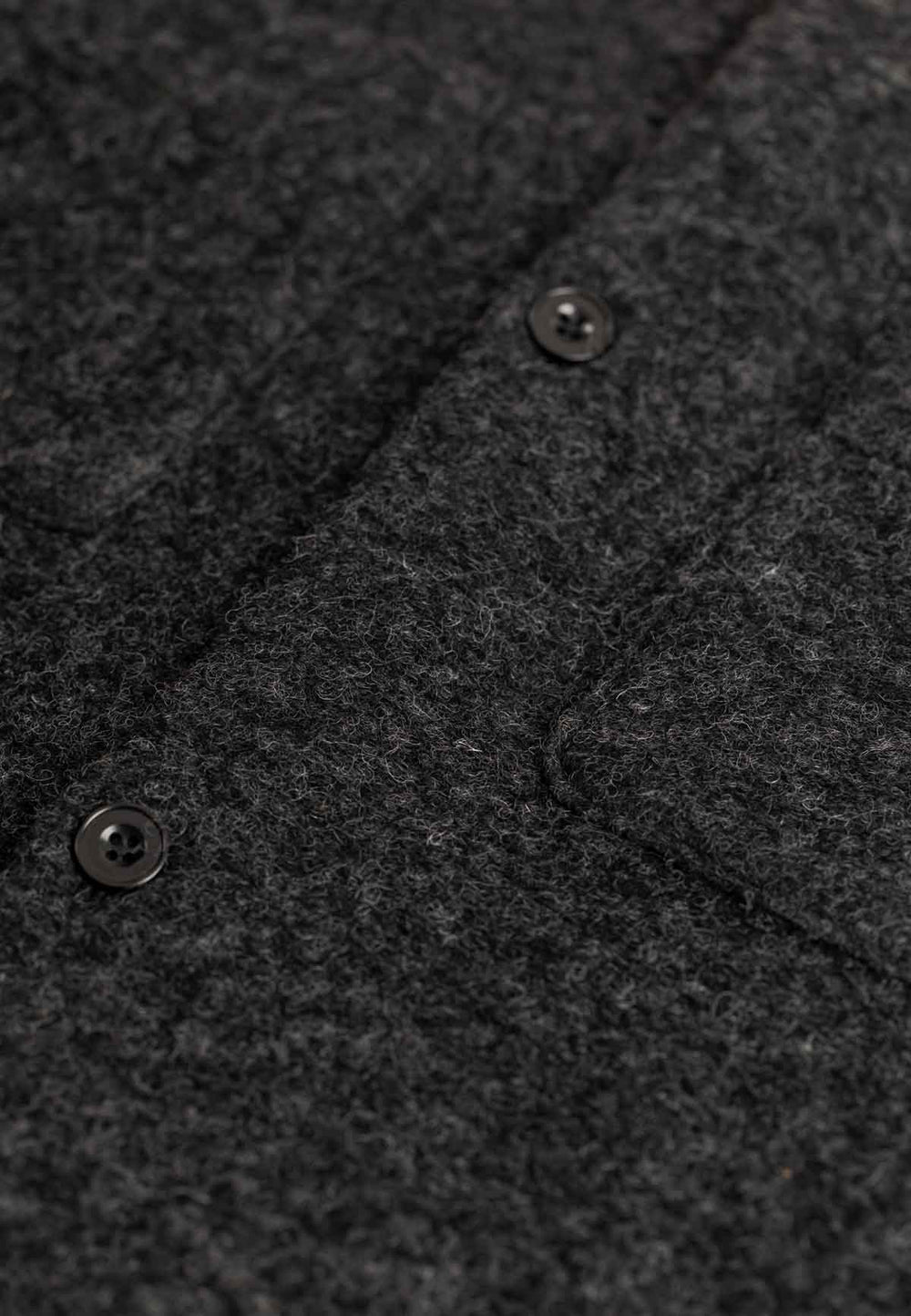 Close up of the button closure of a relaxed overshirt in anthracite.
